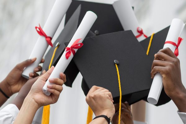 close-up-hands-holding-diplomas-caps (1)